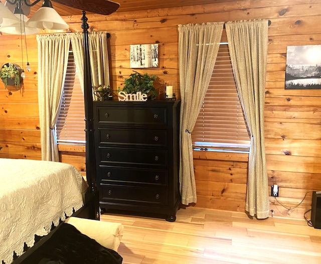 bedroom featuring wood walls and wood finished floors