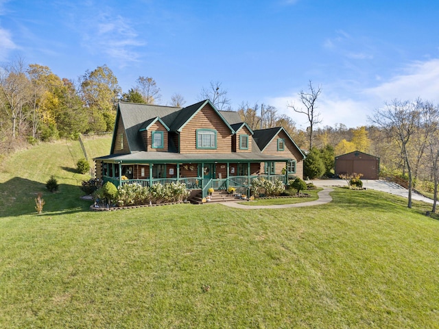 view of front of house with a detached garage, a front lawn, a porch, and an outbuilding