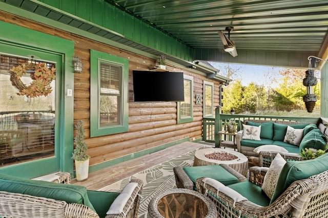 deck featuring an outdoor living space with a fire pit