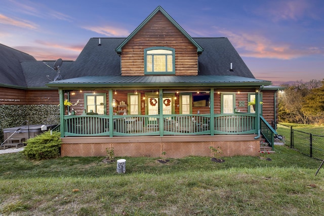 view of front of home with a porch, a front yard, and fence