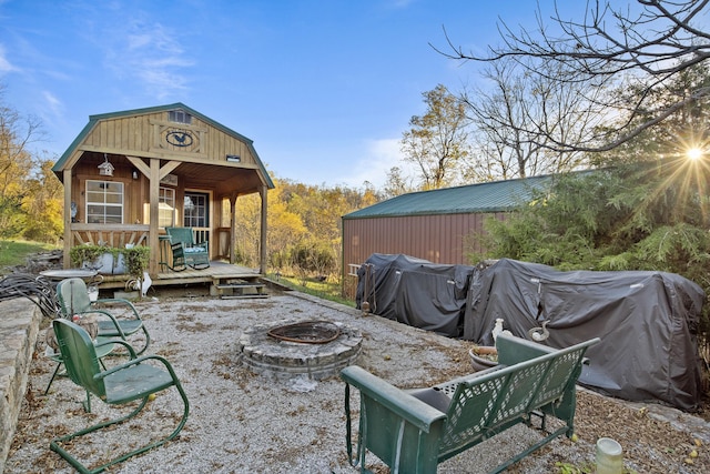 rear view of property with a fire pit and an outbuilding