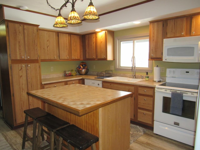 kitchen with light wood-style floors, a kitchen island, a sink, butcher block countertops, and white appliances