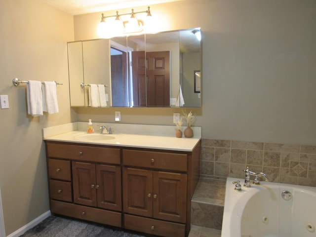 bathroom with baseboards, a tub with jets, and vanity