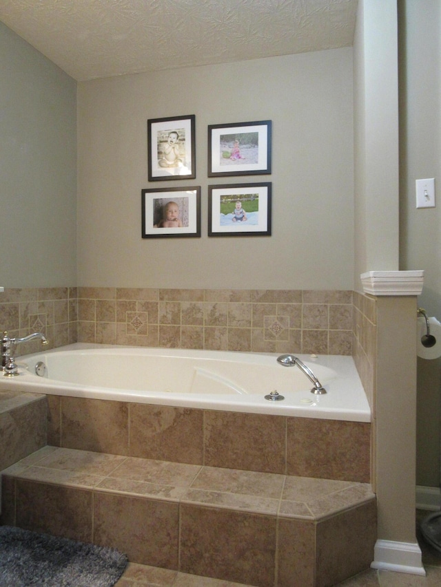 bathroom featuring a textured ceiling and a bath