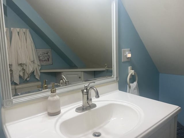 bathroom featuring lofted ceiling and vanity