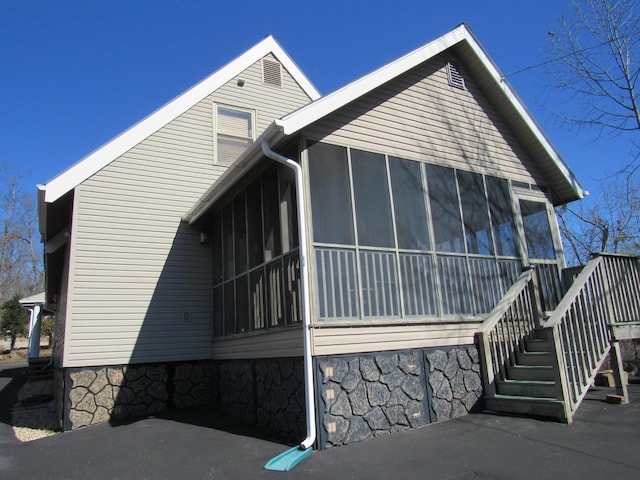 view of property exterior featuring a sunroom