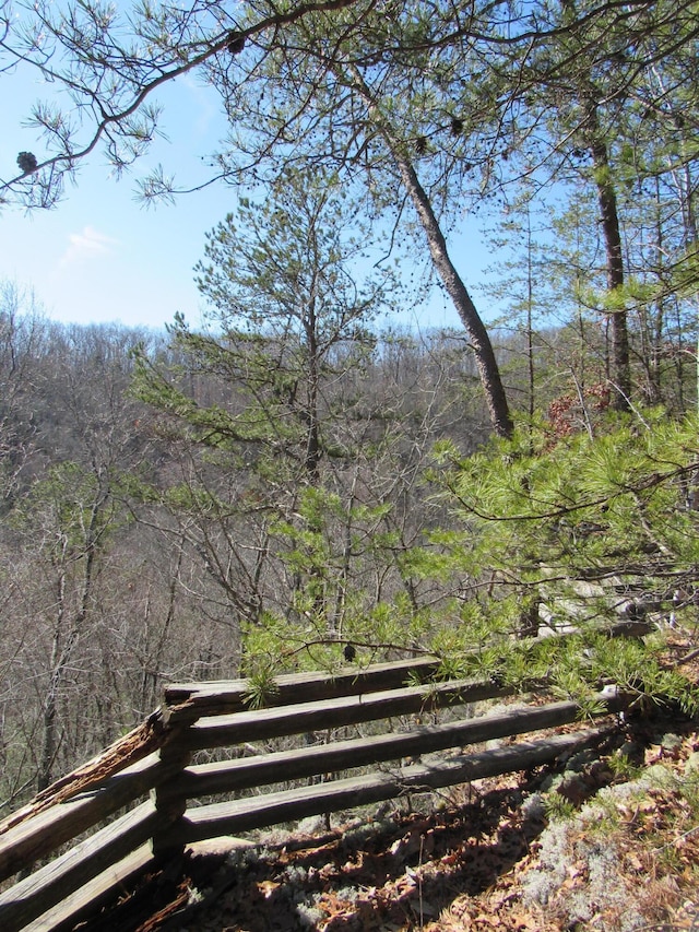 view of community featuring a wooded view and fence