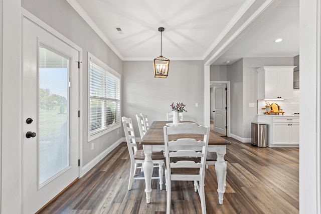 dining room with a chandelier, crown molding, dark wood-type flooring, baseboards, and visible vents