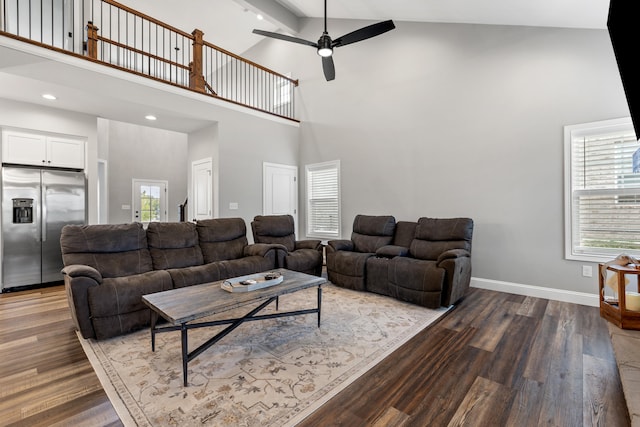 living area featuring high vaulted ceiling, baseboards, ceiling fan, and wood finished floors