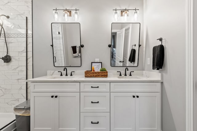 full bath with tiled shower, double vanity, and a sink