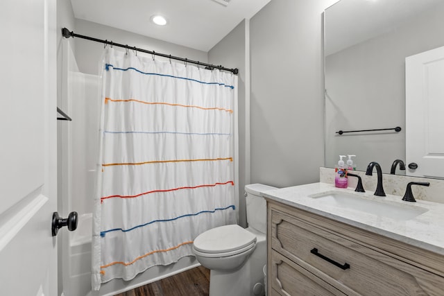 full bathroom with toilet, shower / bath combo with shower curtain, wood finished floors, and vanity