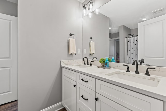 full bath featuring double vanity, a sink, a shower with curtain, and visible vents