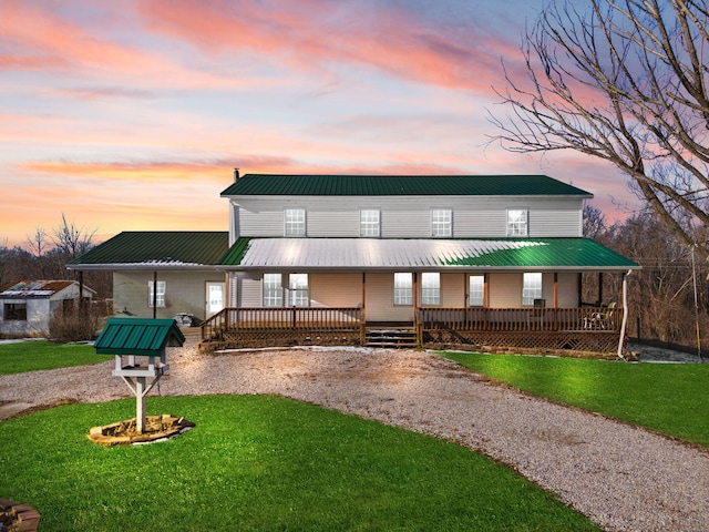 farmhouse with a front yard, covered porch, and metal roof