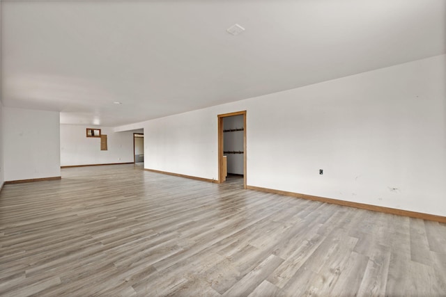 unfurnished living room with light wood-style floors and baseboards