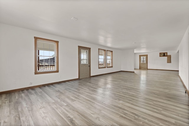 unfurnished living room featuring light wood-style floors and baseboards