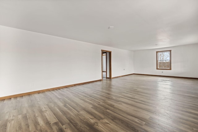 empty room with baseboards and wood finished floors