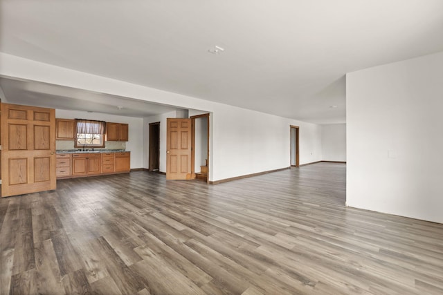 unfurnished living room featuring dark wood finished floors and baseboards