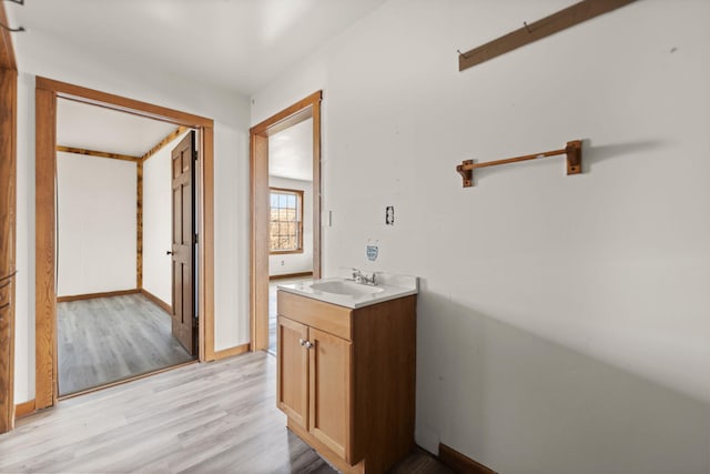 bathroom featuring vanity, baseboards, and wood finished floors