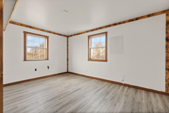 unfurnished room with light wood-style flooring and baseboards