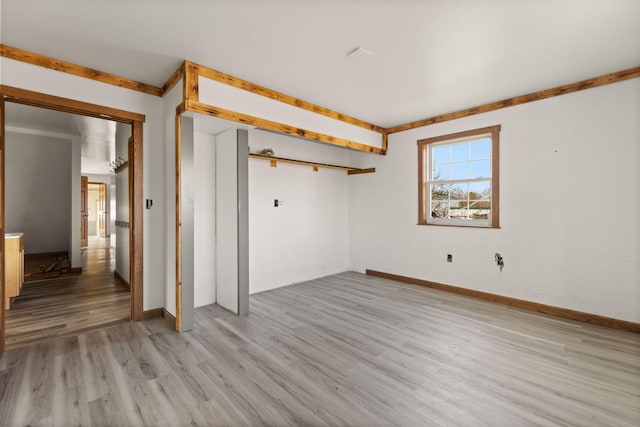 empty room featuring light wood finished floors and baseboards