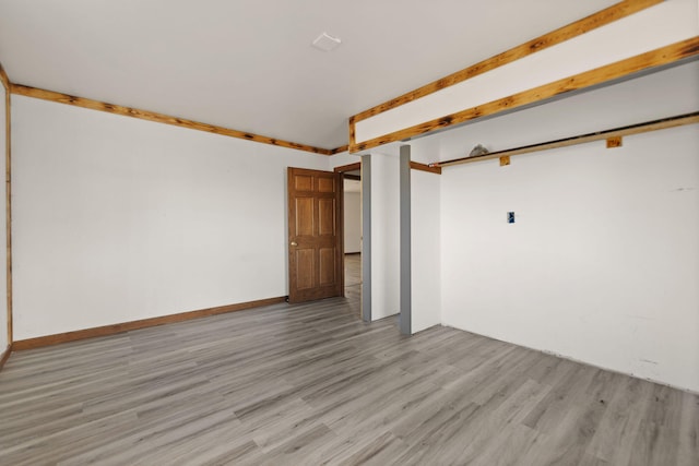 unfurnished room with baseboards and light wood-style floors