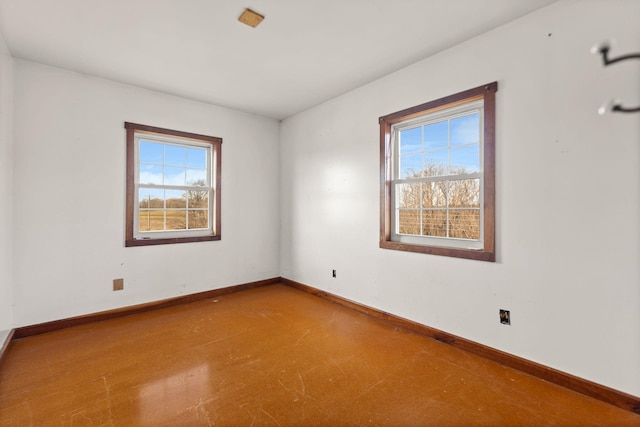 spare room featuring baseboards and a healthy amount of sunlight