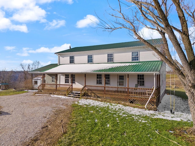 view of front of home with a porch, metal roof, and driveway