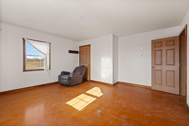 unfurnished room featuring concrete floors and baseboards