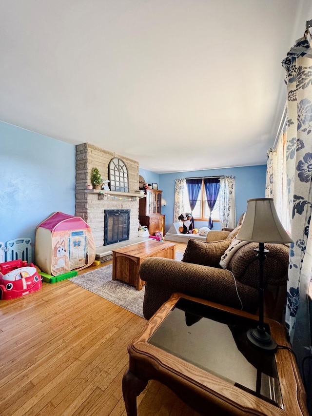 living room with a large fireplace and wood finished floors