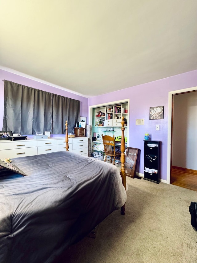 bedroom with baseboards and light colored carpet