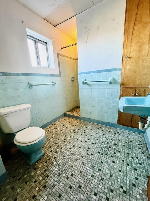 full bath featuring tile walls, toilet, a sink, tile patterned flooring, and tiled shower