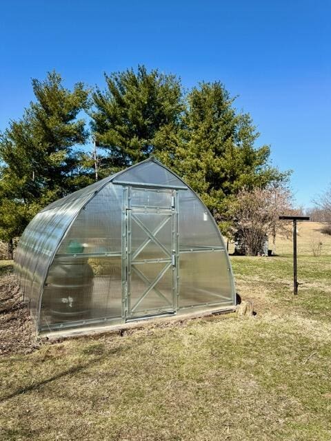 view of greenhouse with a lawn