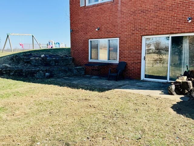 exterior space with brick siding and a lawn