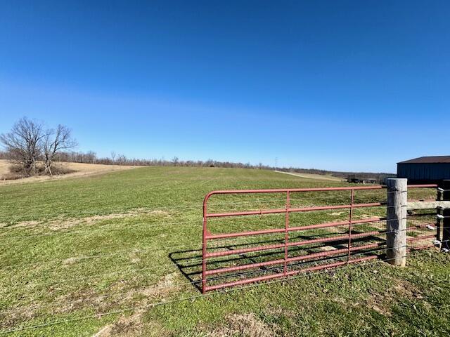 view of gate featuring a rural view and a yard