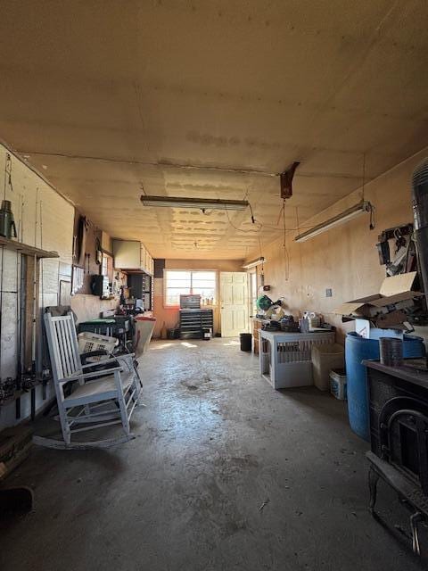 miscellaneous room featuring a workshop area and unfinished concrete floors