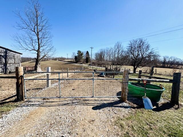 view of yard featuring a gate, a rural view, and fence