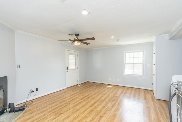 interior space with light wood-style flooring, crown molding, and a wealth of natural light