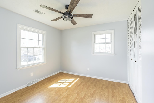 unfurnished bedroom featuring a closet, visible vents, light wood-style flooring, and baseboards