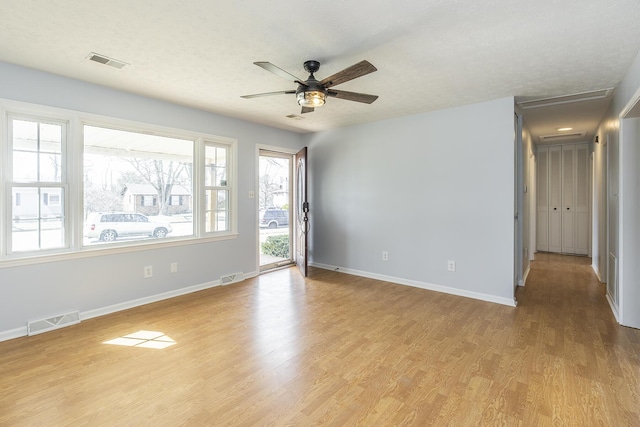 spare room with baseboards, visible vents, and light wood finished floors