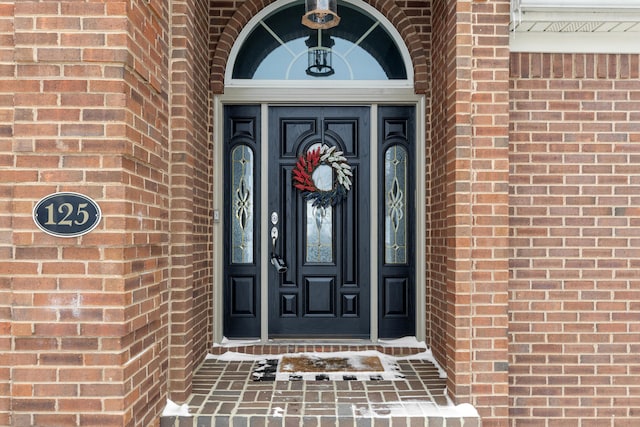 property entrance featuring brick siding