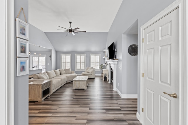 living room with ceiling fan, baseboards, dark wood finished floors, lofted ceiling, and a fireplace