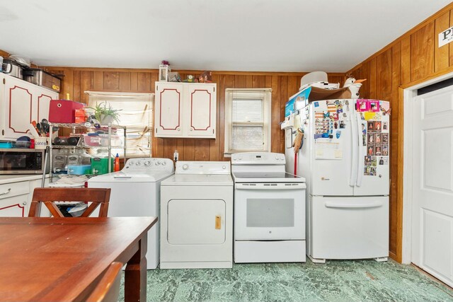 laundry area featuring laundry area, independent washer and dryer, and wood walls