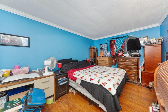 bedroom featuring ornamental molding and light wood-type flooring