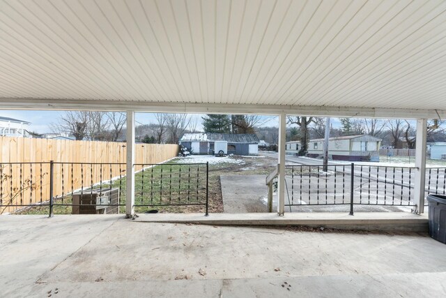 view of patio with an outbuilding and fence