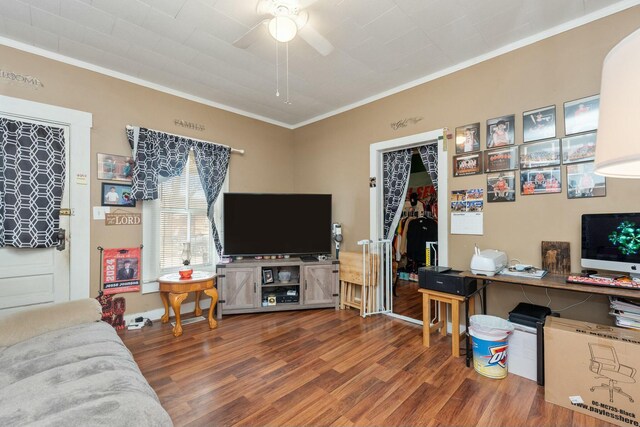 living room with ornamental molding, ceiling fan, and wood finished floors