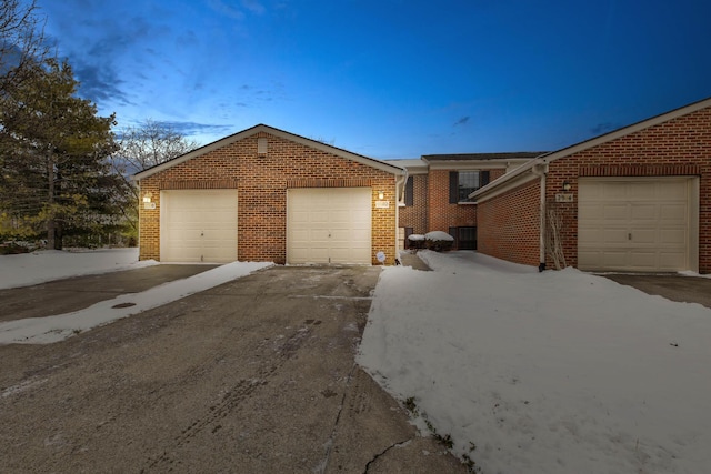 view of front of property featuring driveway, brick siding, and an attached garage