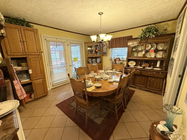 dining room featuring ornamental molding, light tile patterned flooring, a textured ceiling, and an inviting chandelier