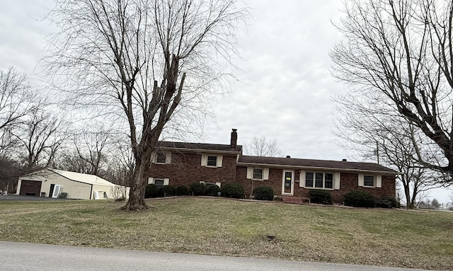 split level home featuring a garage, a front yard, brick siding, and a chimney