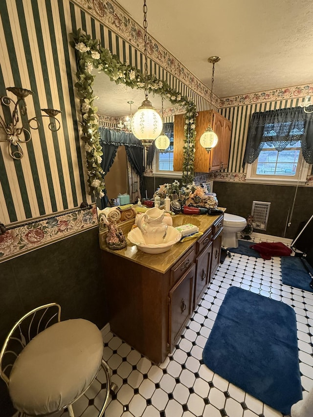 bathroom featuring wallpapered walls, toilet, tile patterned floors, a textured ceiling, and vanity