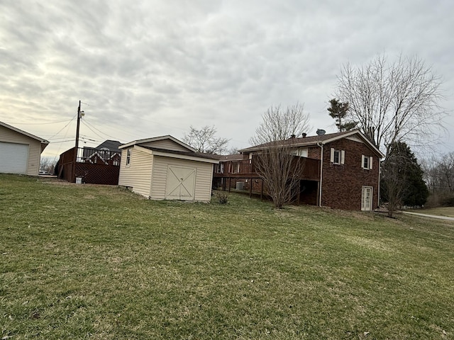 view of yard with an outdoor structure, a wooden deck, and a storage unit